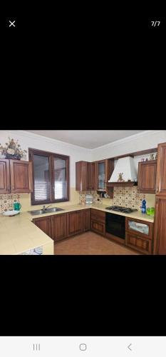 a large kitchen with wooden cabinets and a stove top oven at VILLA MINOLFI in Piazza Armerina