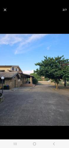 an empty parking lot with a building and a tree at VILLA MINOLFI in Piazza Armerina