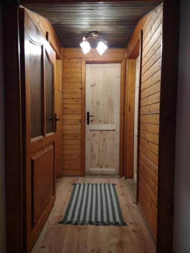 an empty hallway with a door and a rug at Chata v objetí hor: výborná dostupnost a soukromí in Párnica