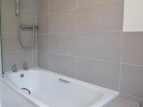 a white bath tub in a bathroom with a shower at Bridge End Cottage in Cregrina