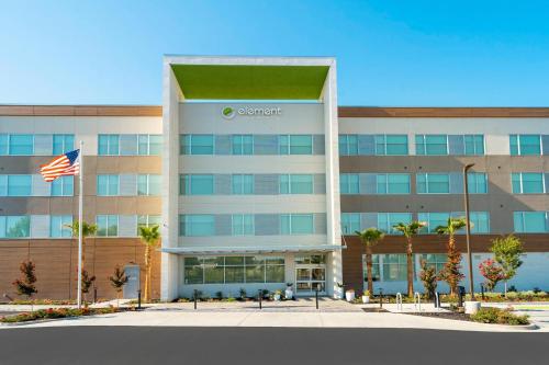 an office building with an american flag in front of it at Element Sacramento Airport in Sacramento