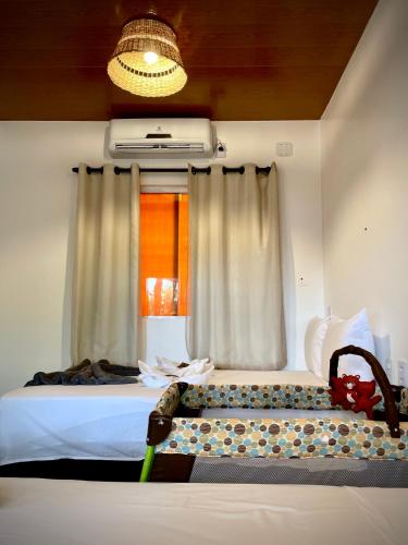 a bedroom with a bed with a window and a couch at Oka Pousada Atins in Atins