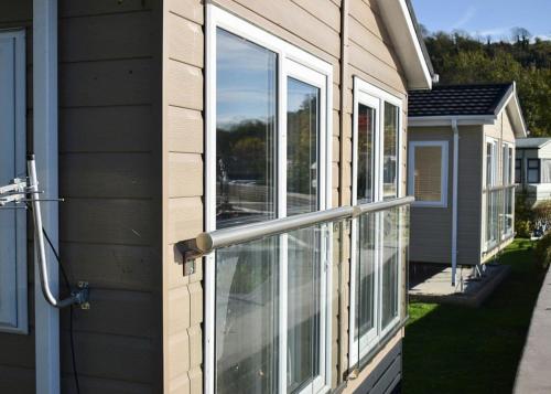 a sliding glass door on the side of a house at Riverside Holiday Park in Amberley