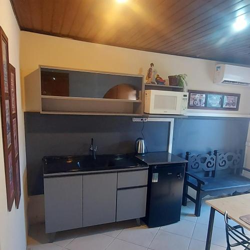 a kitchen with a sink and a microwave at Green Flat in Florianópolis