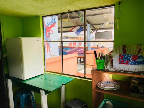 a kitchen with a window and a table and a refrigerator at Zumag Sisa in Tena