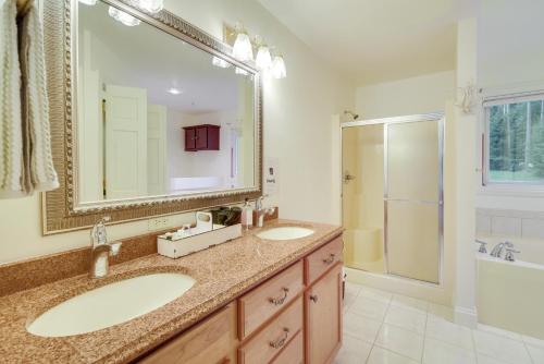 a bathroom with two sinks and a large mirror at Spacious Lakefront New Auburn Home with Sunroom in Chetek