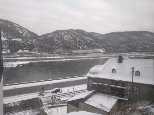 a view of a river with snow on the roof of a building at 100 Stufen über dem Rhein in Oberwesel