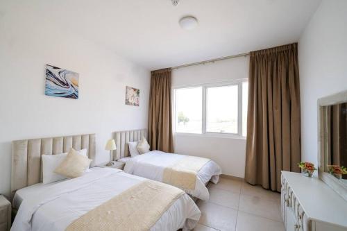 a hotel room with two beds and a window at Elegant 2BR near Palm Jumeirah - 6 Min Drive in Dubai