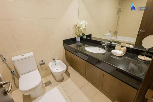 a bathroom with a toilet and a sink and a mirror at Elegant 2BR near Palm Jumeirah - 6 Min Drive in Dubai