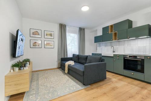 a living room with a couch and a kitchen at Bratislava Touch 2 BR Apt in Bratislava