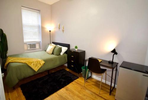 a bedroom with a bed and a desk and a window at Tuk Ahoy - Emerald Suite 3C with Shared Spaces in Brooklyn