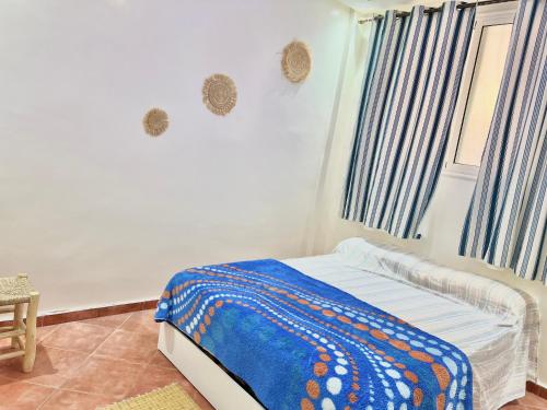 a bedroom with a bed with a blue blanket on it at Moroccan Family House in Agadir