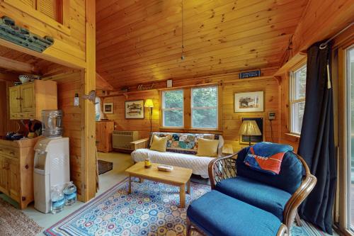 a living room with a couch and a table in a cabin at Beebe Pond Paradise in Castleton