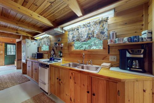 a kitchen with wooden cabinets and a sink at Beebe Pond Paradise in Castleton