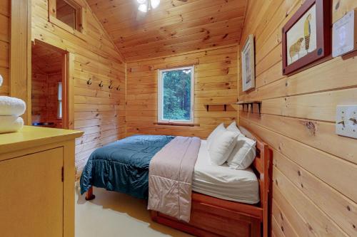 a bedroom with a bed in a wooden cabin at Beebe Pond Paradise in Castleton