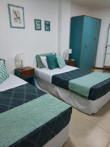 a bedroom with two beds and a blue cabinet at Las Arecas - 3° B in Puerto Iguazú