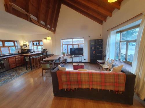 uma sala de estar com um sofá e uma mesa em HABITACIÓN EN CASA DE FAMILIA CERCA DE LA LAGUNA ROOM NEXT TO THe LAGOON em Ushuaia