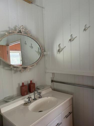 a white bathroom with a sink and a mirror at Montrose on Moore in Linville