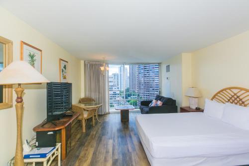 ein Hotelzimmer mit einem Bett und einem Wohnzimmer in der Unterkunft Ilikai Marina 1381 City View Studio in Honolulu