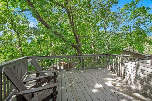 a wooden deck with a tree in the background at The Tulip Tree House in New Buffalo