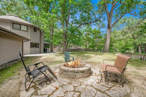 a patio with chairs and a fire pit in a yard at The Tulip Tree House in New Buffalo