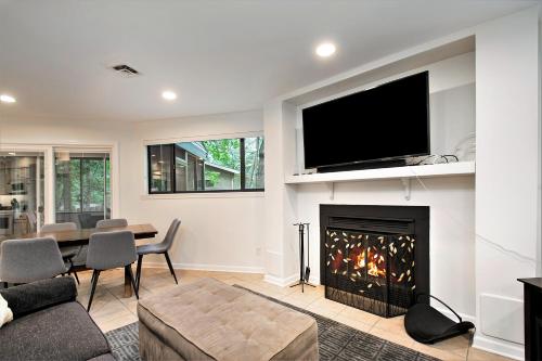 a living room with a fireplace with a flat screen tv at The Tulip Tree House in New Buffalo