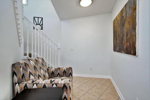 a living room with a chair and a staircase at The Tulip Tree House in New Buffalo