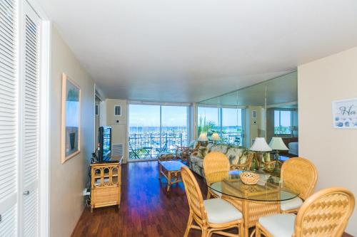 uma sala de estar com mesa e cadeiras em Ilikai Marina 682 Yacht Harbor View 1BR em Honolulu