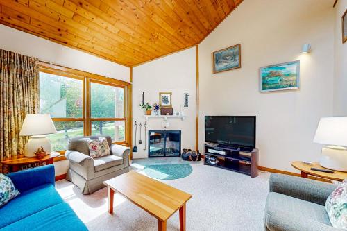 a living room with a couch and a tv at Trail Creek 42 in Killington