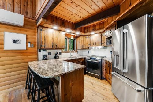 a kitchen with wooden cabinets and a stainless steel refrigerator at Log Cabin Lookout in Bigfork