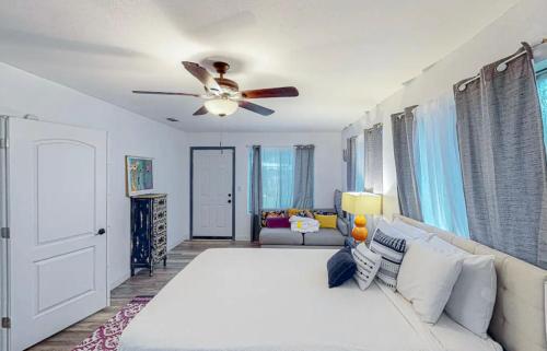 a bedroom with a white bed and a ceiling fan at Peace On The Beach House in Panama City Beach