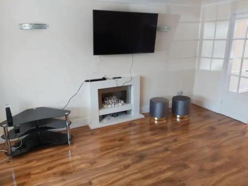 a living room with a flat screen tv above a fireplace at 4 bedroom house houghton regis in Houghton Regis