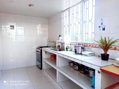cocina blanca con fregadero y ventana en Villa Isabel - Casa Rural, en Paipa