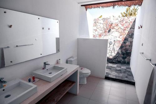 bagno con lavandino, servizi igienici e finestra di Ekas Breaks Resort a Ekas