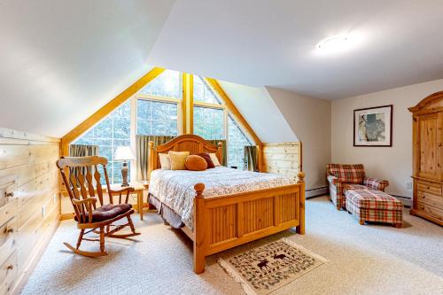 ein Schlafzimmer mit einem Bett und einem großen Fenster in der Unterkunft Sugarloaf Chalet in Carrabassett