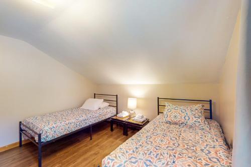 a bedroom with two beds and a table with a lamp at Tranquil Seclusion in Augusta