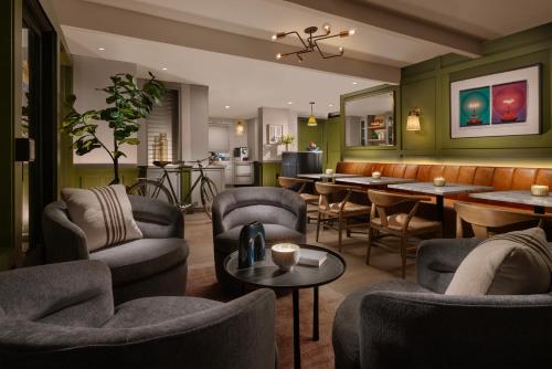 a restaurant with chairs and tables and a bar at The Cottages Hotel in Menlo Park