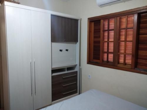 una camera da letto con armadi bianchi, TV e letto di Casa da San a Mongaguá