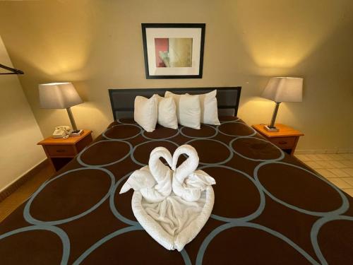 a hotel room with a large bed with a heart decoration at Super 8 by Wyndham Williston ND in Williston
