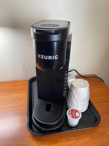a coffee maker sitting on a tray on a table at Super 8 by Wyndham Williston ND in Williston