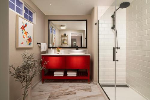 a bathroom with a red sink and a shower at The Cottages Hotel in Menlo Park
