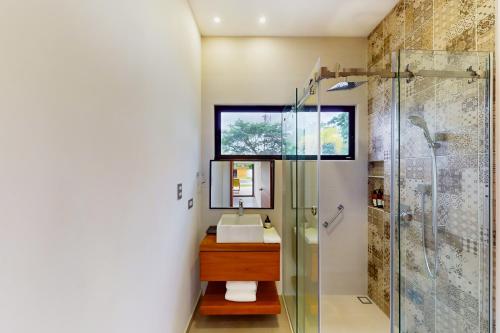 ein Bad mit einem Waschbecken und einer Glasdusche in der Unterkunft Corales 1 in Playa Flamingo
