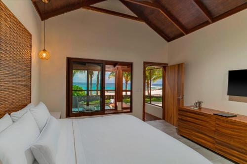 a bedroom with a white bed and a television at The Westin Cozumel in Cozumel