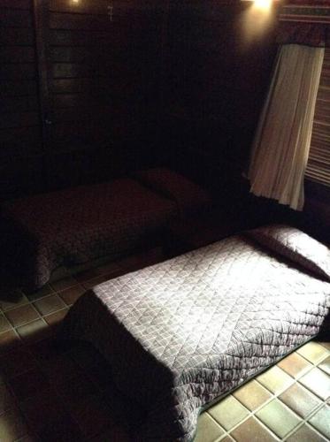a bedroom with a bed in a dark room at Chalé das Helicônias in Guaramiranga
