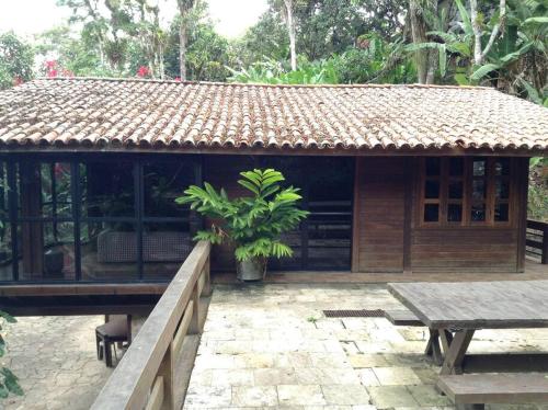 a small building with a table in front of it at Chalé das Helicônias in Guaramiranga