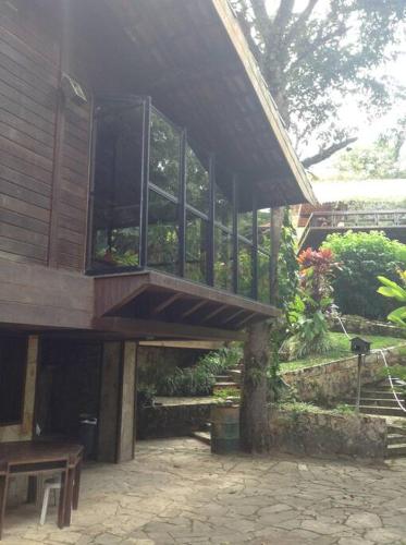 a large building with a balcony and a patio at Chalé das Helicônias in Guaramiranga