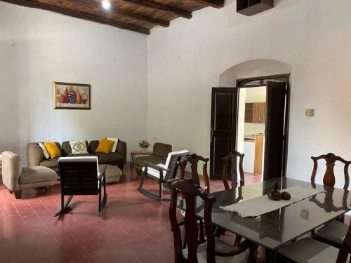een woonkamer met een tafel en stoelen en een bank bij Casa Colonial in Suchitoto