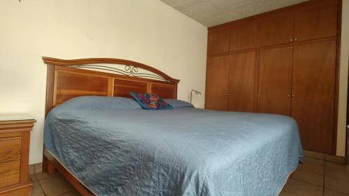 1 dormitorio con 1 cama grande y cabecero de madera en Amplio Apt en Centro Histórico en Oaxaca de Juárez