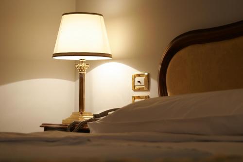 a lamp sitting on a table next to a bed at Grand Hotel Trieste & Victoria in Abano Terme