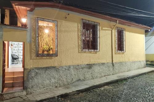 uma casa amarela com janelas do lado em CASA DOS SINOS em São João del Rei